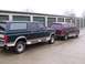 1988 Ford C-350 (Centurion Conversions) - Two Ford SUVs are parked in front of a row of storage unit doors.