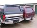1988 Ford C-350 (Centurion Conversions) - Two Ford SUVs, likely Broncos or similar, with camper shells are parked side-by-side.