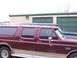 1988 Ford C-350 (Centurion Conversions) - Side view of a maroon extended cab pickup truck and a dark blue SUV parked in front of storage units.