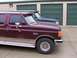 1988 Ford C-350 (Centurion Conversions) - Two trucks are parked side-by-side in front of green storage unit doors.