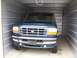 1988 Ford C-350 (Centurion Conversions) - A dark green Ford F-Series truck is parked inside a metal storage unit.