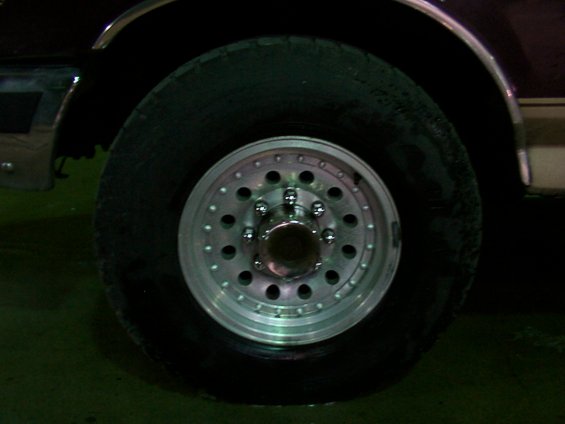 Close-up of a truck's front wheel and tire with a polished aluminum rim