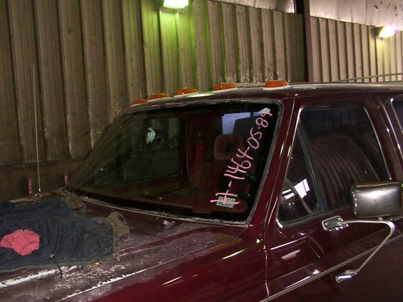 Maroon Ford F-Series truck windshield with pink writing '#-1464-05-89' and a sticker