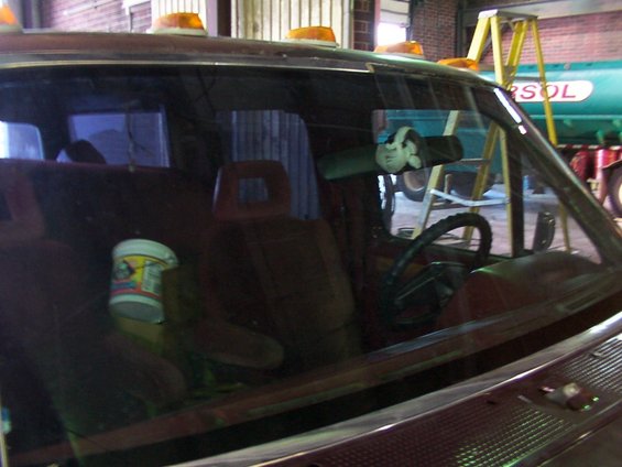 1988 Ford C-350 (Centurion Conversions) interior showing maroon seats, steering wheel, and dashboard. A bucket is on the passenger seat
