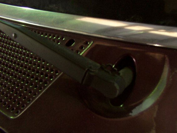 Windshield wiper assembly on a dark red vehicle