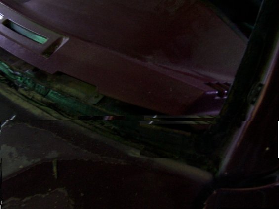 Close-up of the base of a windshield, showing the wiper mechanism and surrounding trim