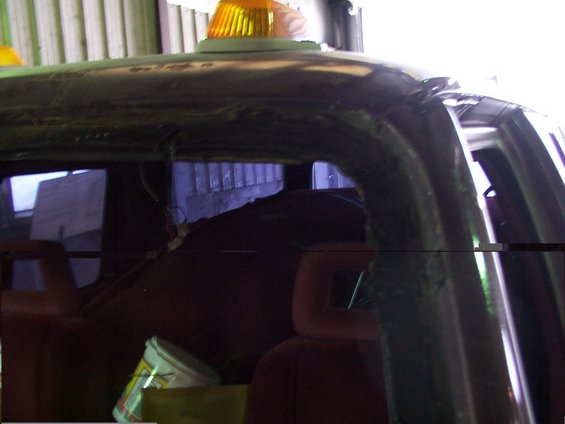 Dark interior of a truck with a yellow emergency light on the roof. Red seats and buckets are visible