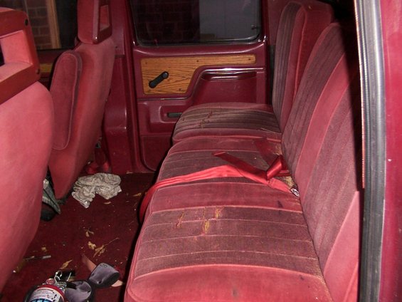 Red velour bench seats and door panel with wood trim inside a 1988 Ford C-350 (Centurion Conversions)