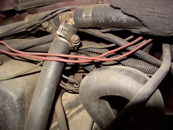Close-up of engine bay hoses and wiring with visible text '5/8" 16m'