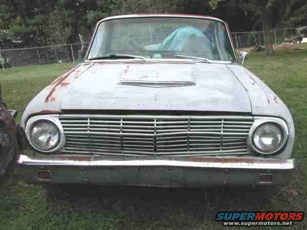 Front of a weathered 1960-1963 Ford Falcon Ranchero with a horizontal bar grille and a hood scoop