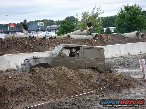 Muddy 1988 Suzuki Samurai navigating a mud bog