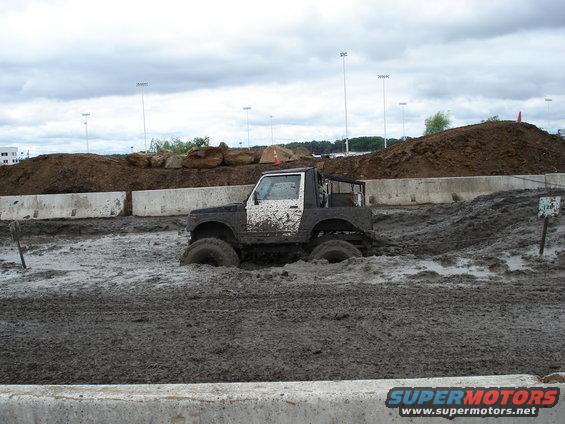 Jeep-like vehicle deep in mud pit, tires submerged