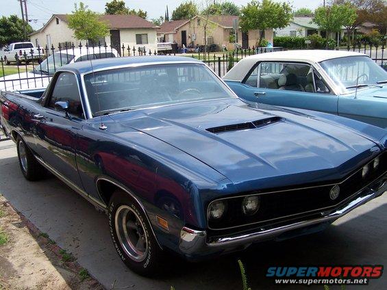 Blue 1970 Ford Ranchero parked next to a light blue coupe