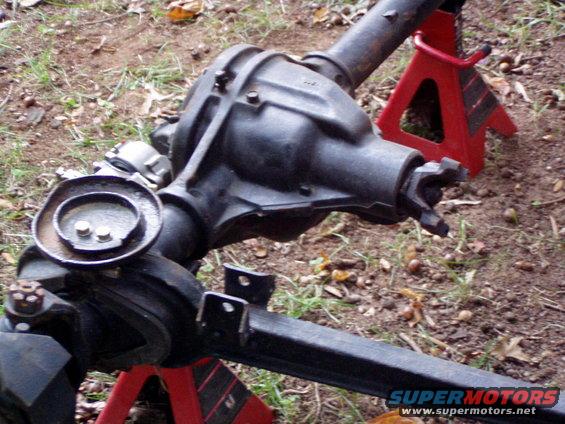 Differential axle assembly on red jack stands, showing driveshaft yoke and differential cover