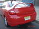 2005 Dodge SRT-4 - Rear view of a red Dodge Neon SRT-4 with a prominent spoiler and dual exhaust pipes, parked on a street.