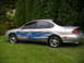 1999 Ford Taurus - This sedan features custom blue flame decals along its side, with chrome wheels and a spoiler.