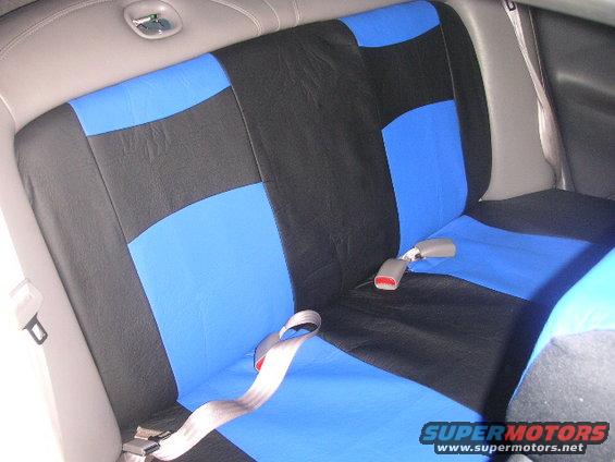 Back seat with blue and black seat covers and seatbelts