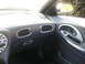 1999 Ford Taurus - The interior of a car is shown, focusing on the dashboard, air vents, and door handle with decorative trim.