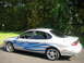 1999 Ford Taurus - Side view of a silver 1999 Ford Taurus custom blue flame graphics and chrome wheels.