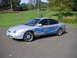 1999 Ford Taurus - A silver sedan with custom blue flame decals is parked outside on a paved surface.