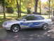 1999 Ford Taurus - A silver 1999 Ford Taurus sedan is shown from the side, blue flame decals and chrome wheels.