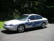 1999 Ford Taurus - A silver sedan with custom blue flame decals is shown from a three-quarter front angle.