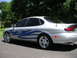 1999 Ford Taurus - This 1999 Ford Taurus features custom blue tribal graphics and chrome wheels, seen from the rear 3/4 angle.