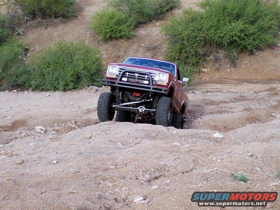 Red lifted off-road truck on a dirt trail