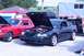 2006 Ford Mustang - A dark green coupe, possibly a GT model, is parked with its hood open at an outdoor event.