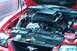 2006 Ford Mustang - The engine bay of a red 2006 Ford Mustang is shown with the hood open, revealing the engine and various components.