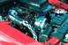 2006 Ford Mustang - The engine bay of a red 2006 Ford Mustang shows a Cobra supercharger and custom intake system.