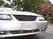 2000 Ford Mustang - The front of a silver car with a custom grille is shown, with a house in the background.