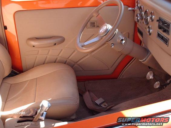 Tan interior with custom door panel, bucket seat, and steering wheel