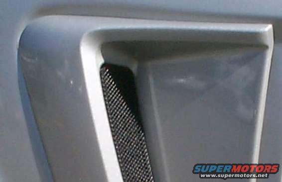 Side scoop mesh cover on a vehicle, showing a black mesh insert within a gray housing
