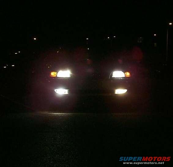 Car front at night, headlights and fog lights illuminated