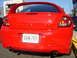 2005 Dodge SRT-4 - Rear view of a red Dodge Neon SRT-4 with a prominent spoiler and dual exhaust pipes.
