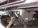1988 Ford C-350 (Centurion Conversions) - A close-up view of a tow hitch assembly on a red truck, showing a heavy-duty chain and hook.