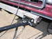 1988 Ford C-350 (Centurion Conversions) - Trailer hitch assembly and safety chains attached to the frame of a vehicle.