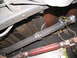 1988 Ford C-350 (Centurion Conversions) - Underside view of a vehicle's driveshaft and exhaust system, secured with wire and tape.