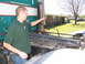 1988 Ford C-350 (Centurion Conversions) - Man points to the exhaust stack of a large truck, with a house and yard in the background.