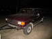 1988 Ford C-350 (Centurion Conversions) - This maroon SUV has a trailer hitch and is parked on a concrete surface at night.