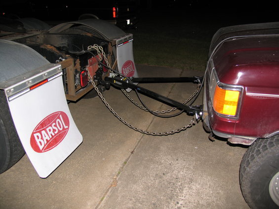 Maroon vehicle being towed by trailer hitch. Visible "BARSOL" text on mud flaps
