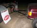 1988 Ford C-350 (Centurion Conversions) - A maroon vehicle is connected to a trailer hitch for towing. The mud flaps on the trailer display the "BARSOL" logo.