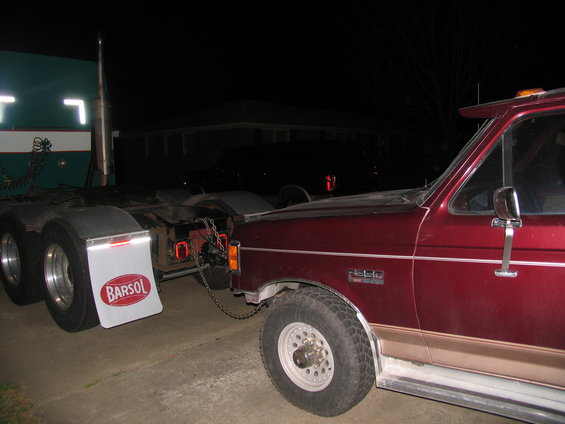 Maroon Ford F-250 truck towing a semi-trailer, side view