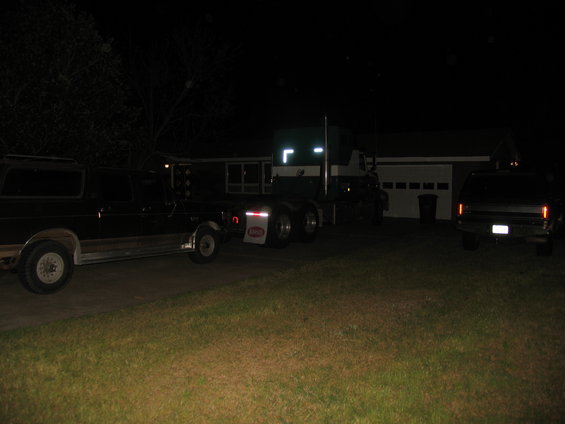 Black Ford Bronco with a trailer hitch, seen from the side at night