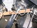 1988 Ford C-350 (Centurion Conversions) - Underneath view of a truck's chassis, showing various mechanical components and a person's hand.