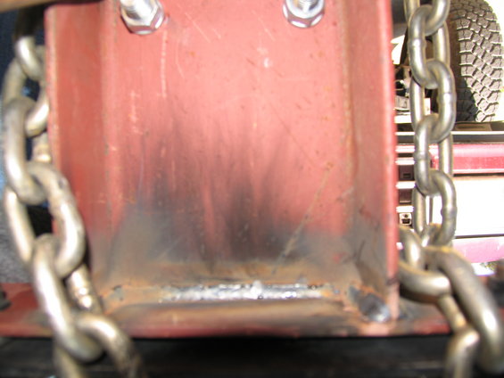 Chains wrapped around a red metal bracket with visible welds
