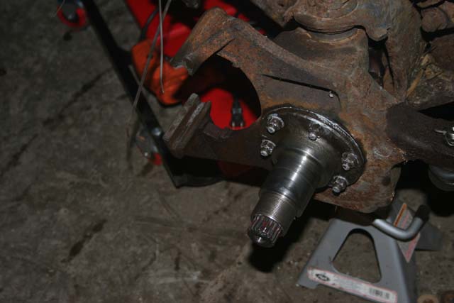 rusted vehicle suspension assembly with hub and splined spindle, supported by jack stands