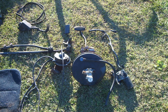 Vehicle brake booster, master cylinder, steering linkage, and other parts laid out on grass