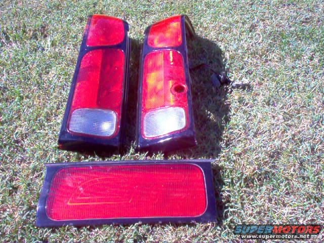 Three red car tail lights laid out on grass